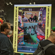 People stand on line in front of a screen showing the Heavy Metal magazine cover
